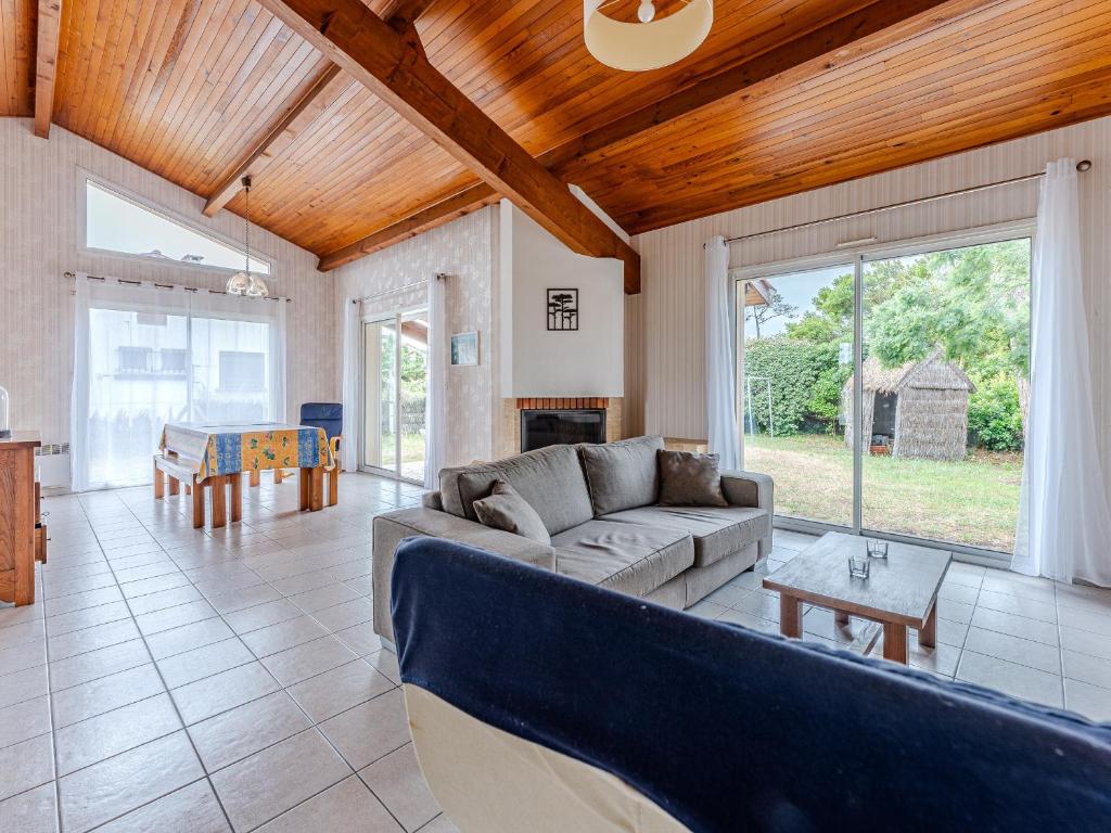 un salon avec un canapé et une table dans l'établissement Maison à Biscarrosse: proche plage, commerces, jardin, terrasse avec BBQ, 5 pers, garage - FR-1-521-247, à Biscarrosse