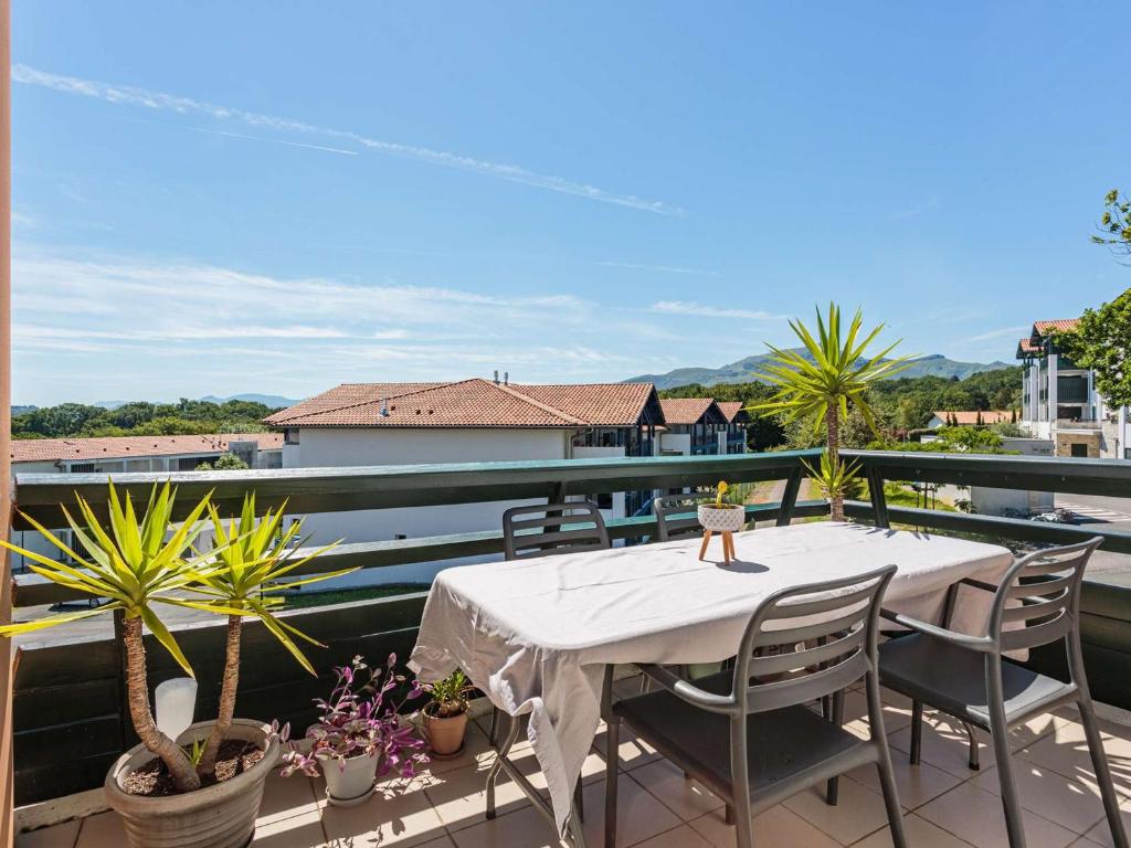 d'une table et de chaises sur un balcon orné de plantes. dans l'établissement Bel appartement duplex à Ciboure avec terrasse proche golf Nivelle - FR-1-4-696, à Ciboure