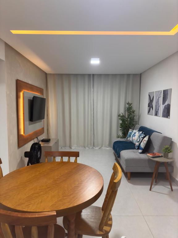 a living room with a table and a couch at Caminho do Mar - Apartamento com excelente localização in Rio das Ostras