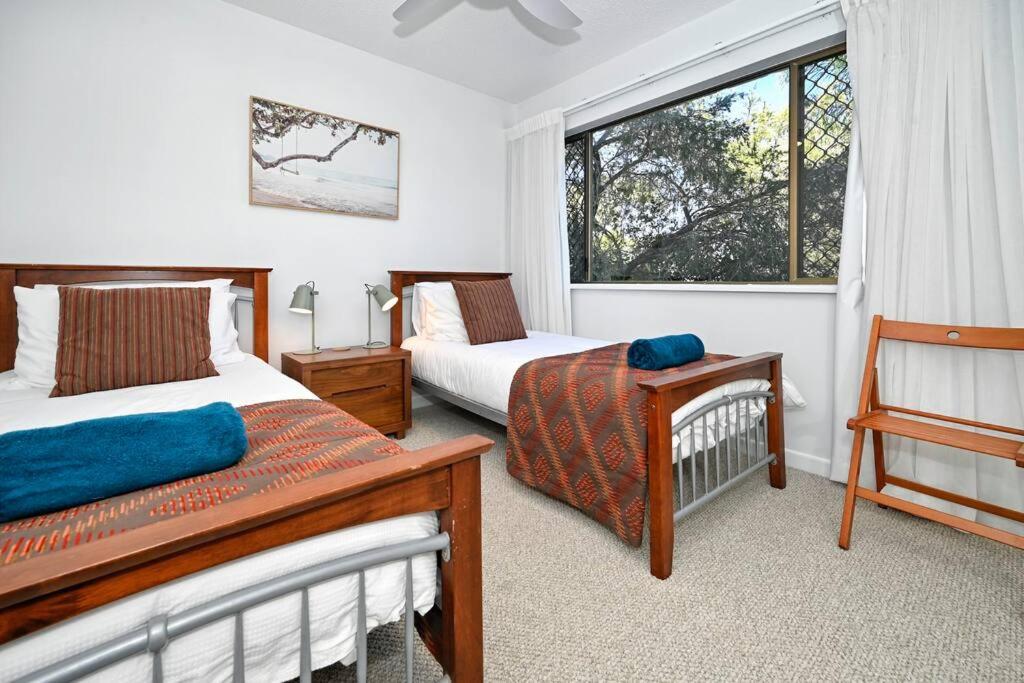 una camera da letto con due letti e una finestra di Mooloolaba Tranquil Hideaway a Mooloolaba
