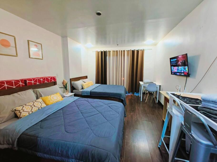 een hotelkamer met twee bedden en een televisie bij Baguio Condotel - City Center in Baguio