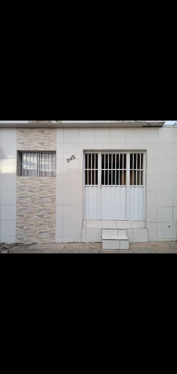 a white building with two garage doors and windows at Festa de São João in Campina Grande
