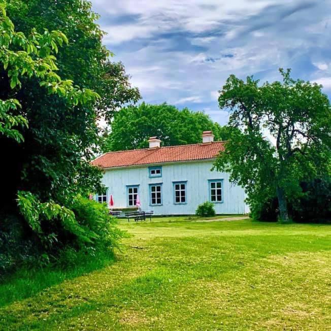 a white house with a bench in a yard at Mossebo Gästhem in Vimmerby
