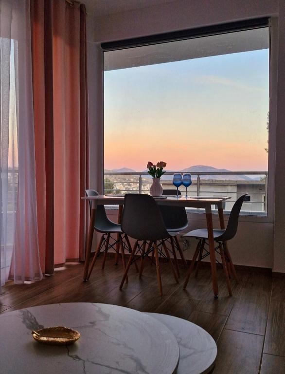a dining room with a table and a large window at Villa Virginia in Sarandë