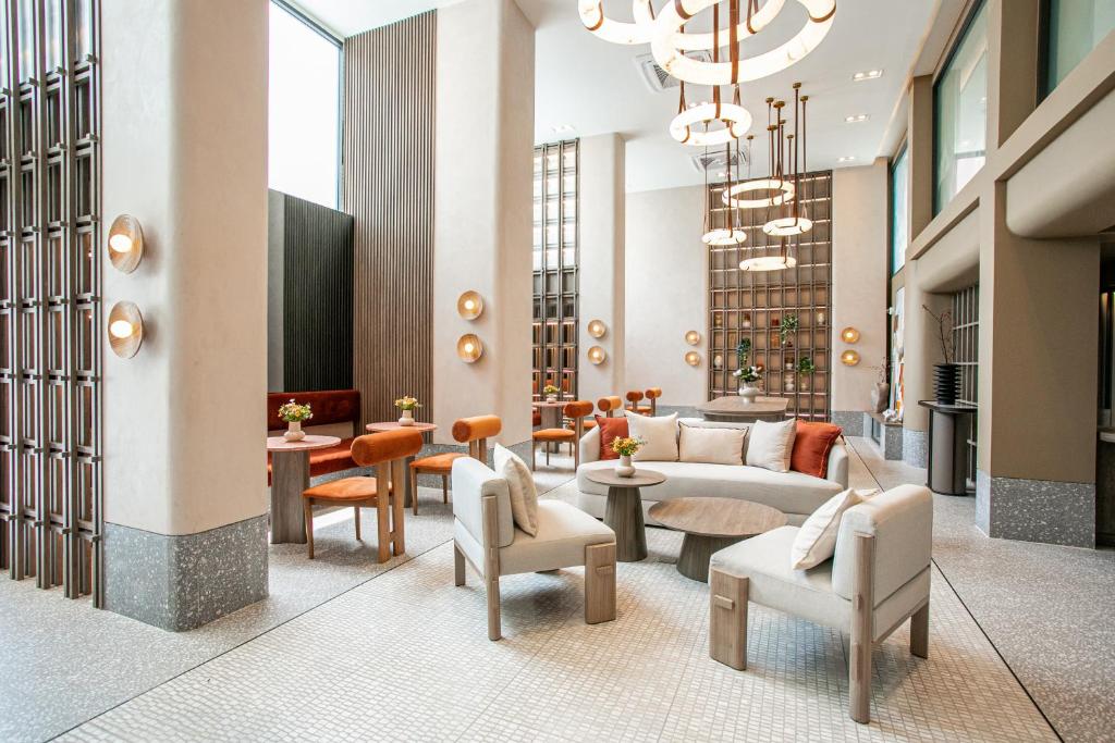 a lobby with a couch and chairs and tables at Pillow B Hotel in Ban Zong Katiam
