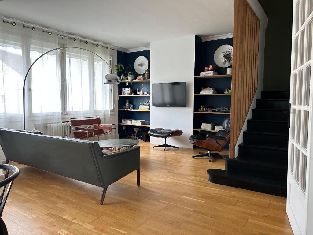 - un salon avec une baignoire et un escalier dans l'établissement maison d'Adrien et Mathilde, au Mans