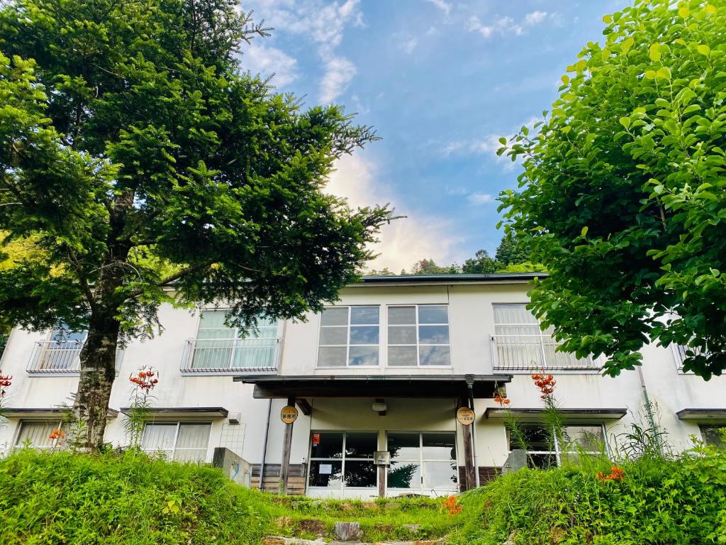 Ōdoにある山茶小屋 Yamachagoyaの目の前に木々が植えられた白い家