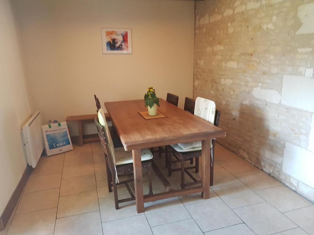 a dining room table with chairs and a vase on it at Le Logis de la Pataudière in Champigny-sur-Veude