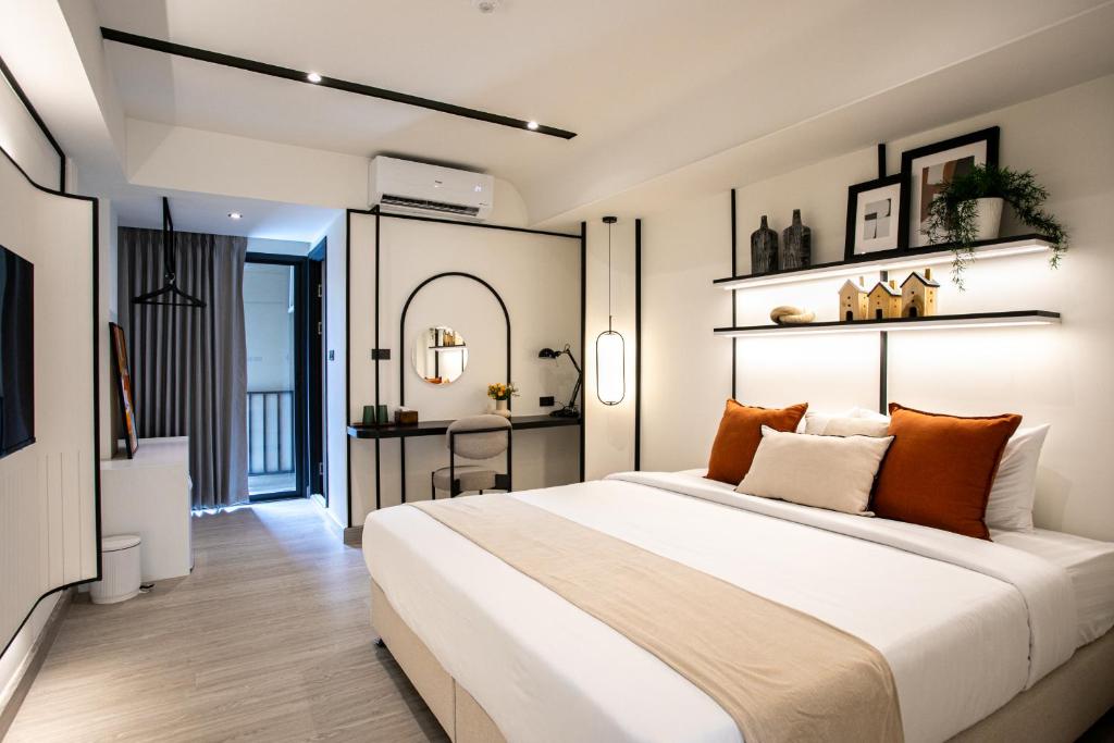 A modern king room with a large bed, wall-mounted television, and compact work desk.
