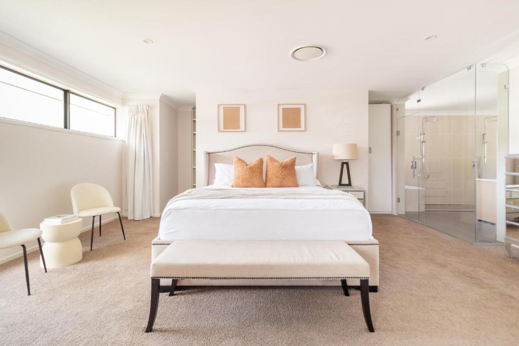 a white bedroom with a large bed with orange pillows at Luxury Spacious 5 Bedroom Family Modern Villa Sleeps 10 in Waterford