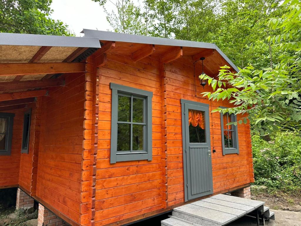 a small wooden cabin with a bench in front of it at Dream House in Batumi