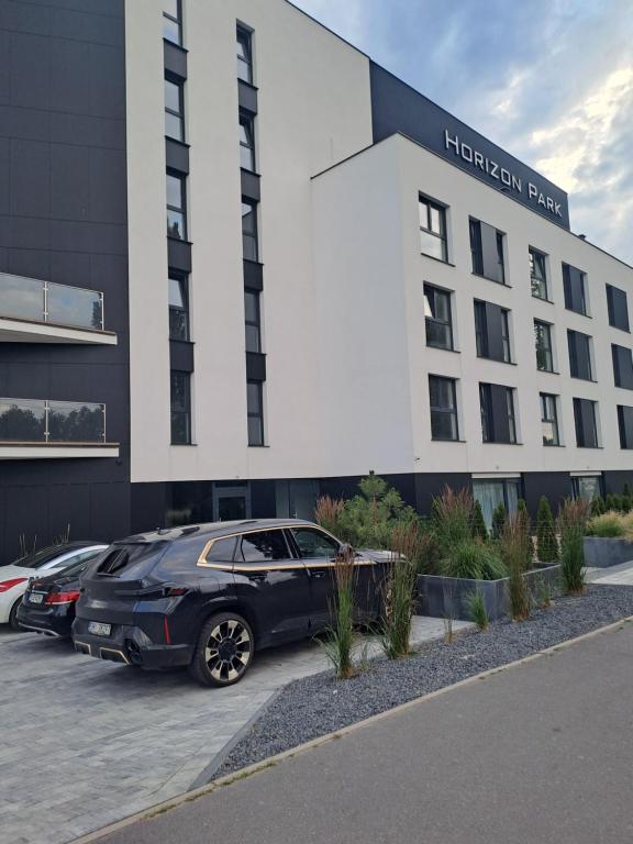a car parked in a parking lot in front of a hotel at Horizon Park Boszkowo in Boszkowo-Letnisko