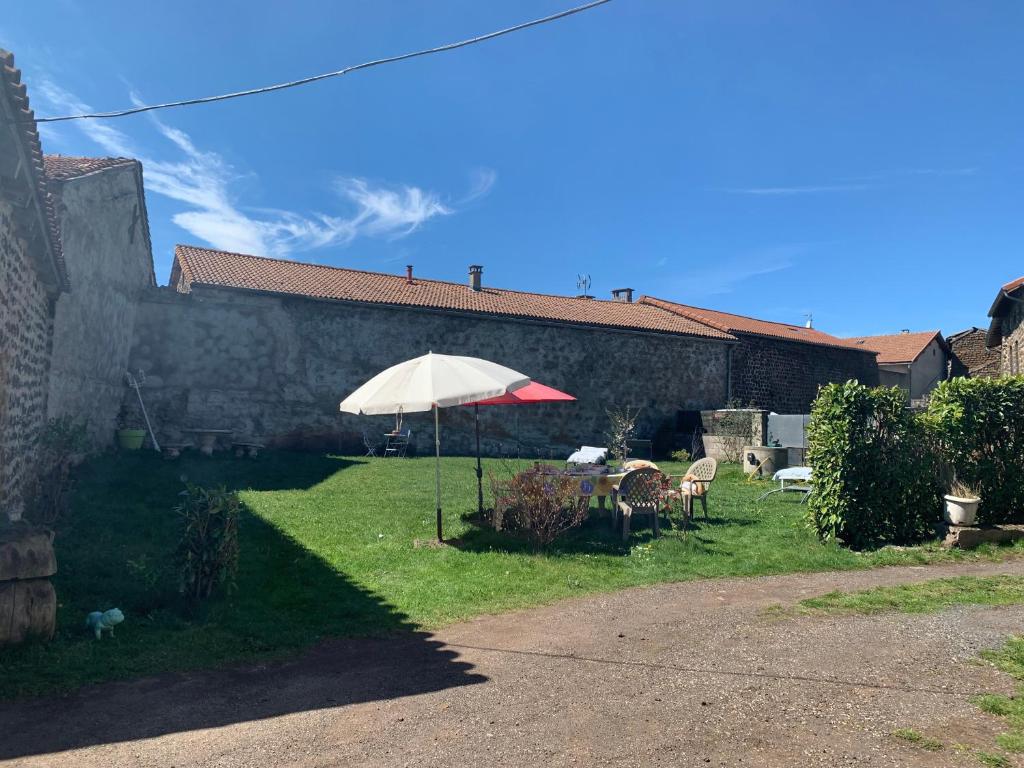 a table with an umbrella in front of a building at la belle étape in Le Bouchet-Saint-Nicolas