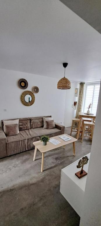 un salon avec un canapé et une table dans l'établissement Le balinais , en hyper centre rue au calme avec parking, à Cherbourg en Cotentin