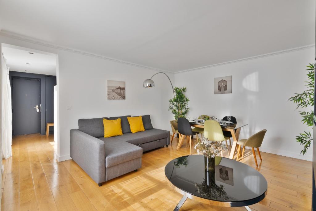 un salon avec un canapé et une table dans l'établissement Appartement Quartier Opéra 2 Free Netflix, à Paris