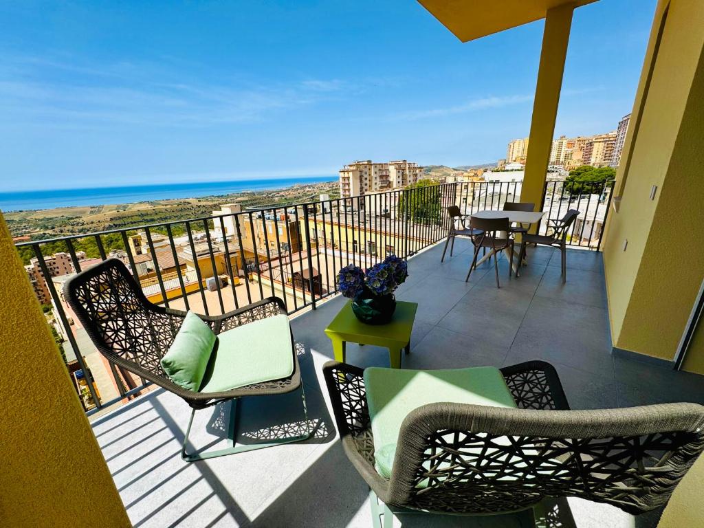 balkon z krzesłami i stołem i oceanem w obiekcie Deluxe apartment Milia Agrigento w mieście Agrigento