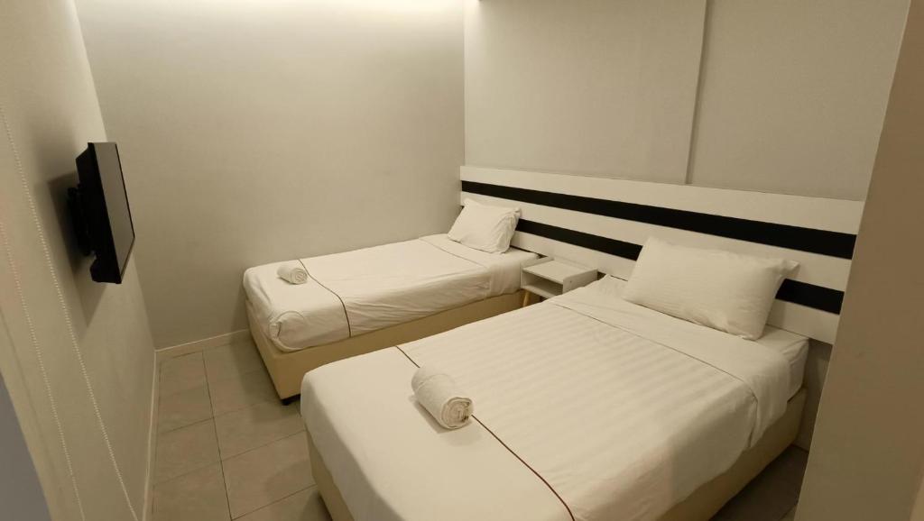 Letto o letti in una camera di LEA GUEST HOUSE & CAFE Lukut