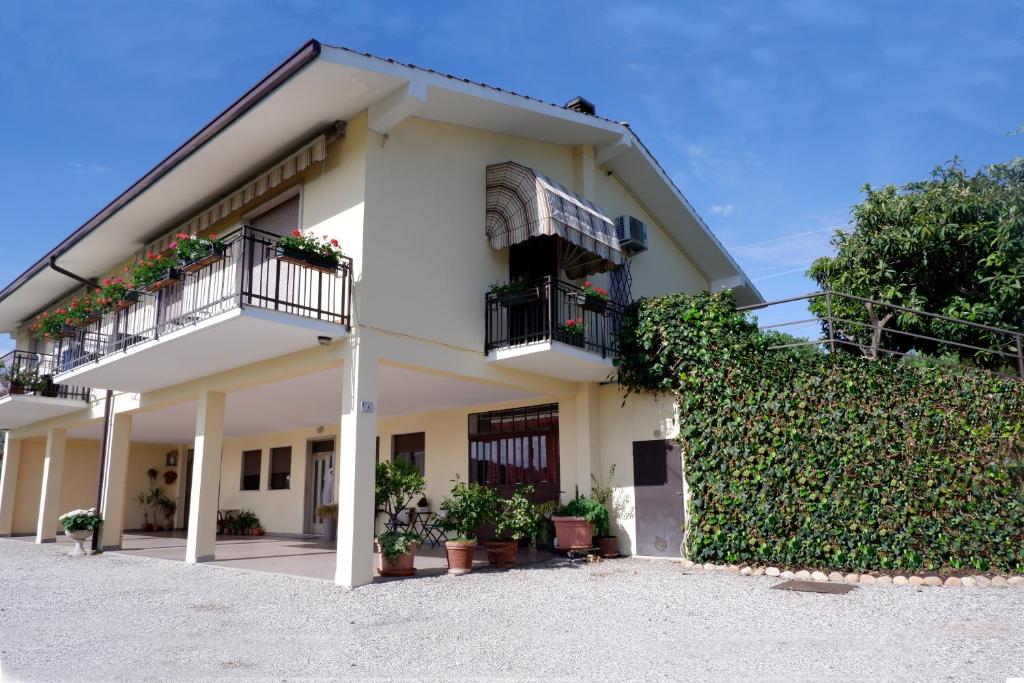 a building with two balconies and a hedge at L'edera appartamento in Rivoli Veronese