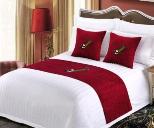 a bedroom with a white and red bed with red pillows at Dramaga Tower Apartemen by Rendy Roomme in Bubulak 3