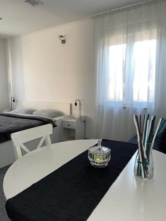 a white room with a table and a bed at WHOLE HOUSE FOREST-yard and BBQ, private parking in Marinići