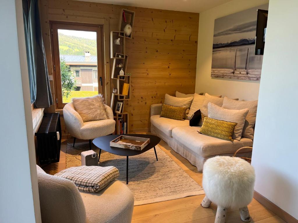 un salon avec deux canapés et une table dans l'établissement Appartement rez de jardin Megeve, à Megève