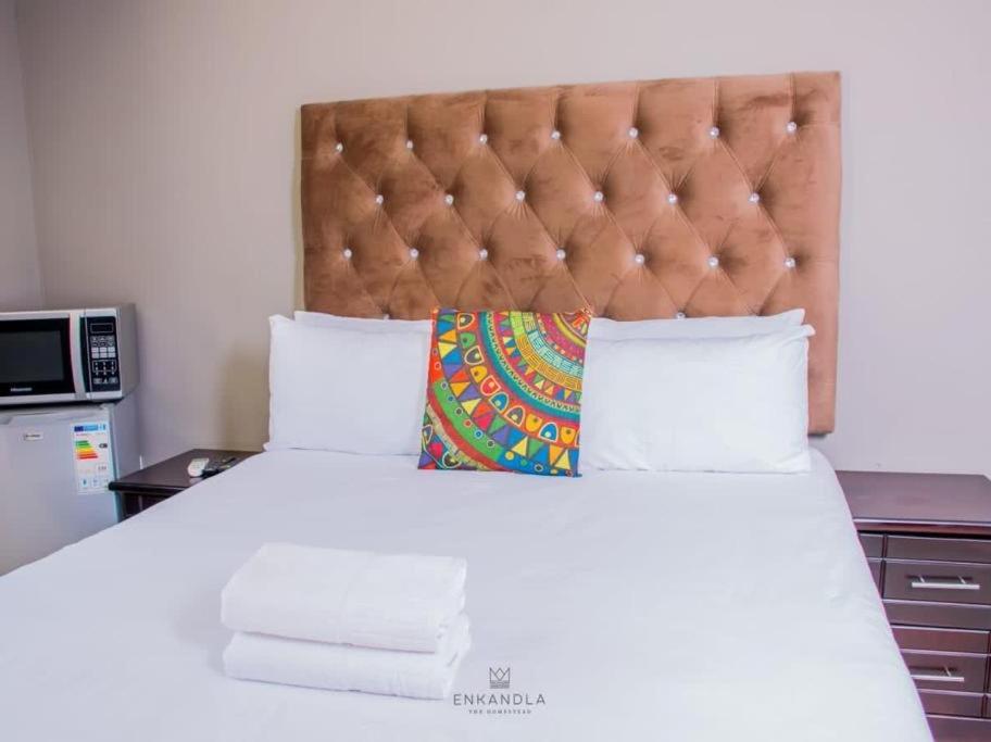 una camera da letto con un grande copriletto bianco di The homestead resort a Mabhoko