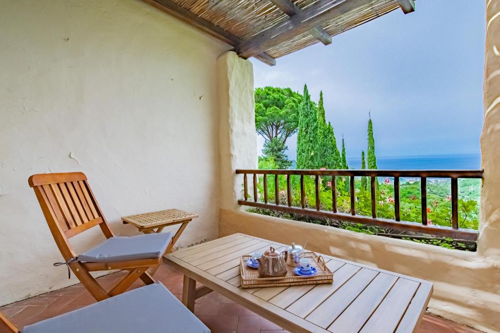 a table and a chair on a balcony with a view at Tenuta Bussadori - Casa Del Timoniere in Poggio