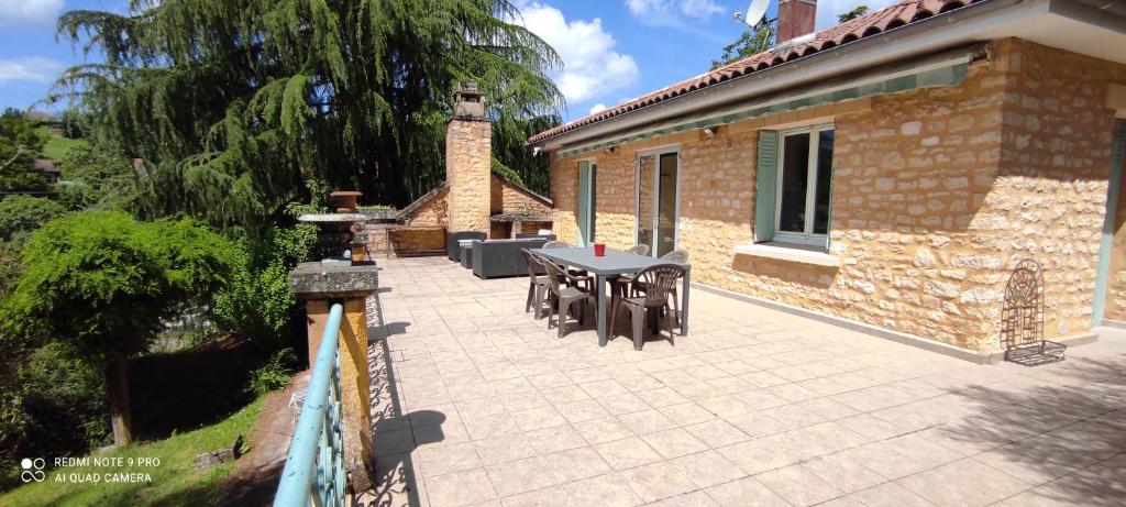 un patio avec une table et des chaises à côté d'un bâtiment dans l'établissement Maison avec jolie vue, 5mn à pied du centre, à Sarlat-la-Canéda