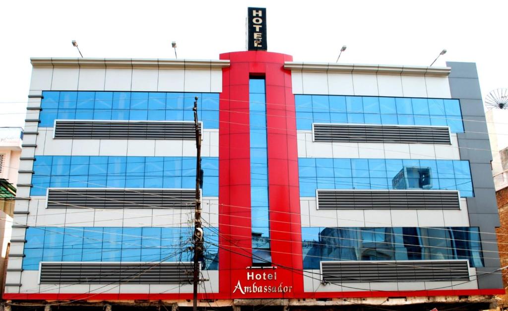 a building with a red stripe on the side of it at Hotel Ambassador Inn in Gwalior