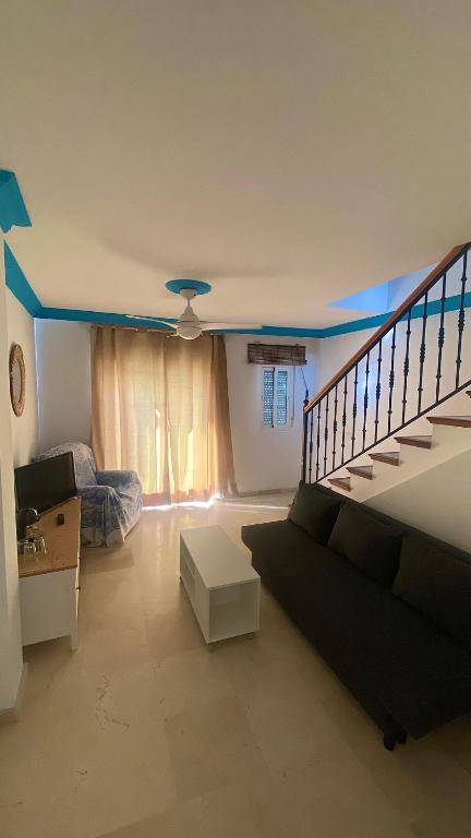 a living room with a couch and a staircase at Loving Mediterranean Home in Estepona