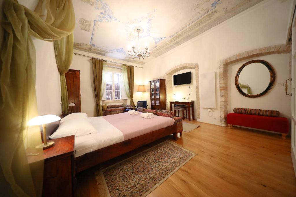 a bedroom with a large bed and a mirror at Petrizio Palace in Zadar