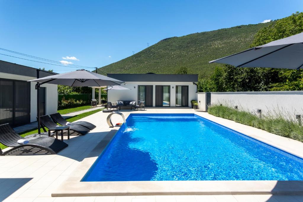 a swimming pool in the backyard of a house at Holiday Home Noa in Mostar