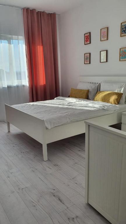 a large white bed in a room at La Ana Apartament in Şelimbăr