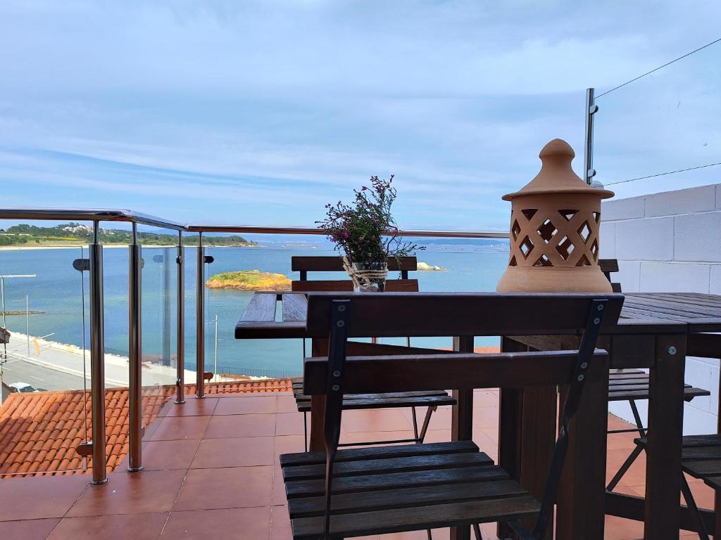 a table and bench on a balcony with a view of the ocean at Casa Boa Vista in San Pedro