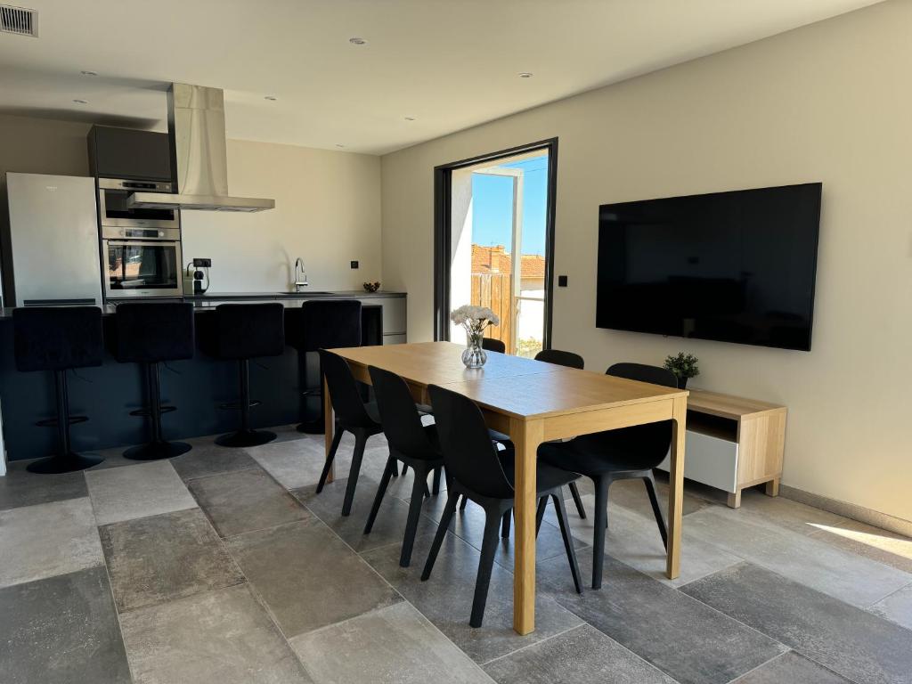 comedor con mesa de madera y sillas negras en L'appartement Lavande, en Le Lavandou