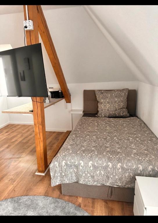 una piccola camera da letto con un letto e una TV di Room Deluxe a Meerbusch