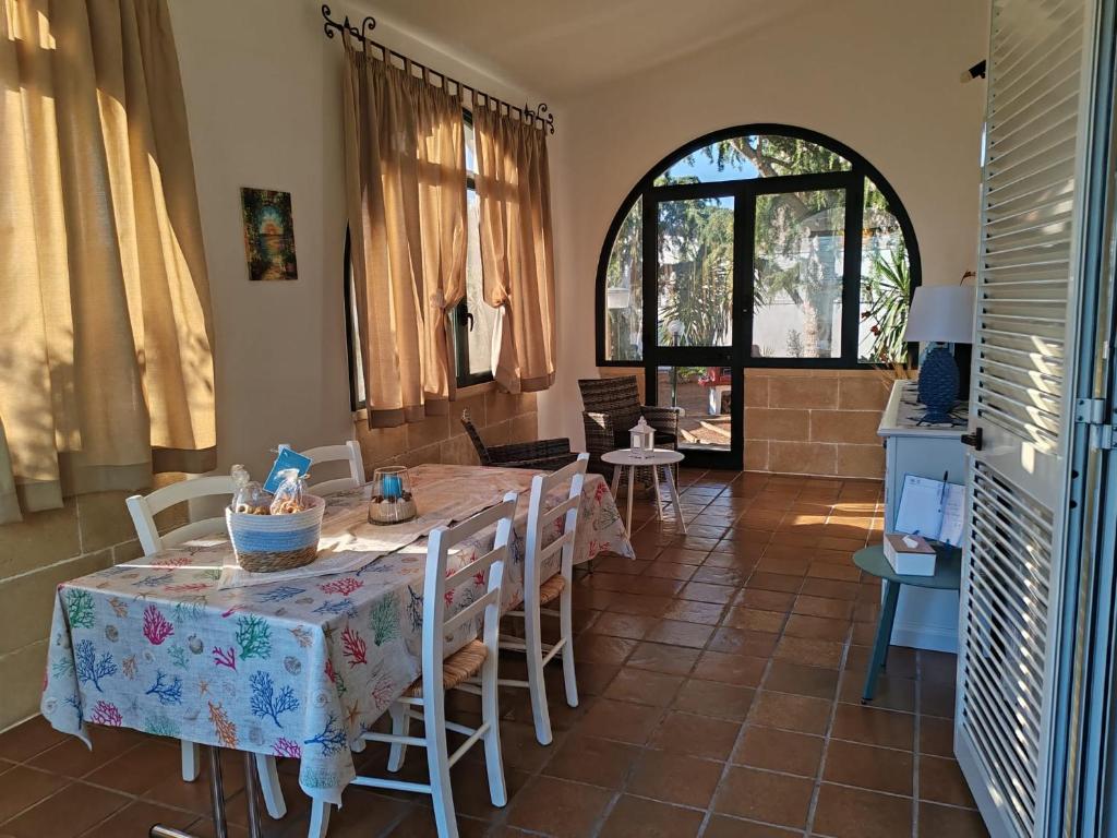 a dining room with a table and chairs at A L' ARIA FRISCA - villetta a due passi dal mare in Torre Lapillo