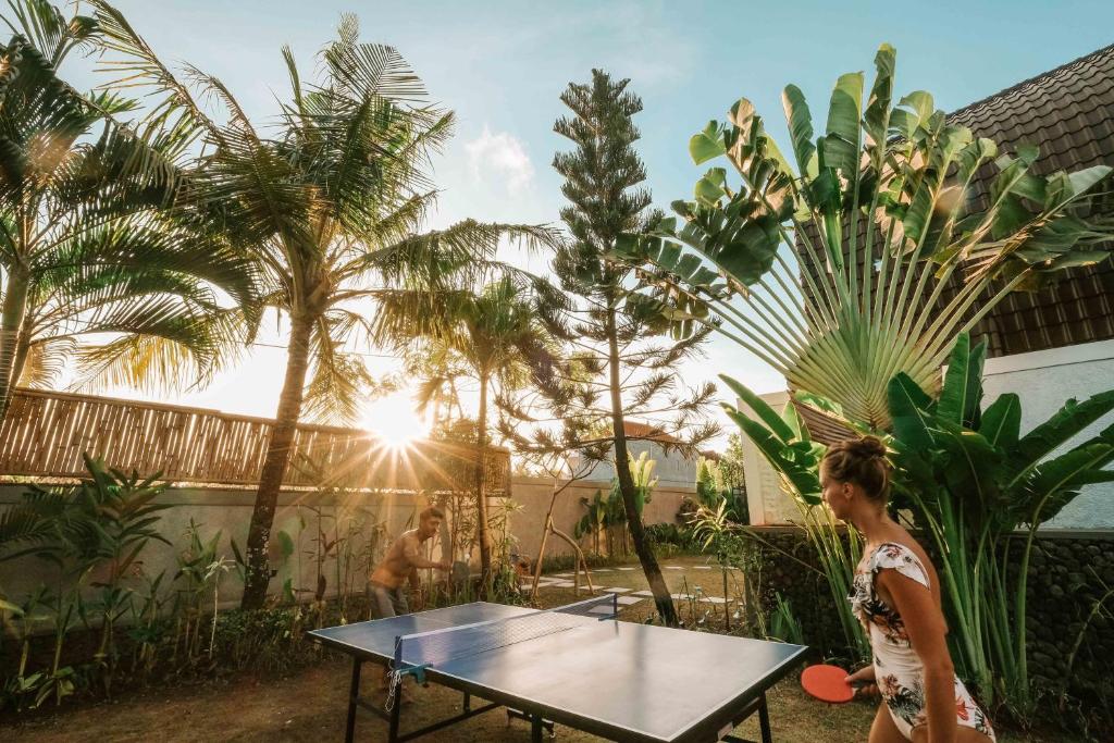 a woman standing next to a ping pong table at The Palms Canggu in Canggu