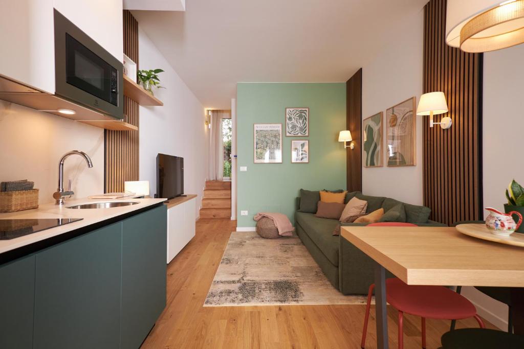 a kitchen and living room with a couch and a table at Orti29 - Luxury Stay Bologna in Bologna