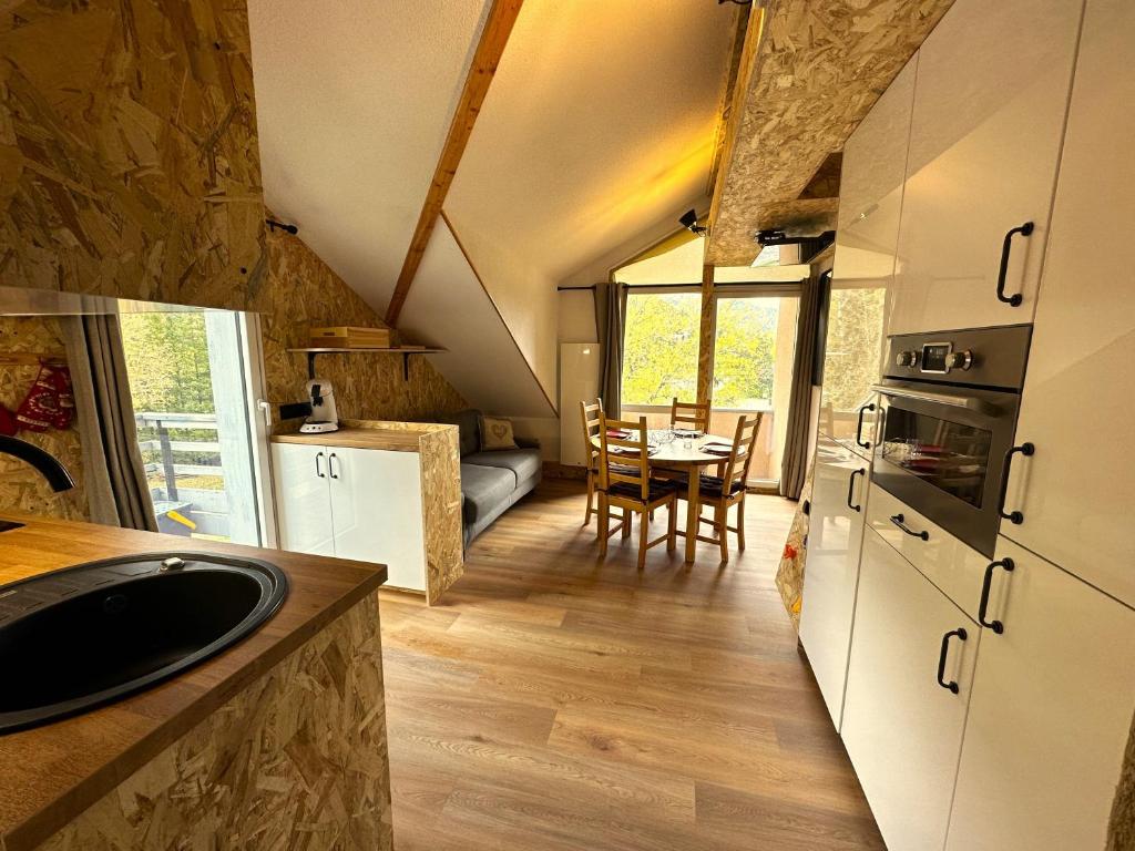 - une cuisine et une salle à manger dans une petite maison dans l'établissement LES CIMES DE CADELIO , 5 à 7 personnes, Proche base de loisirs et remontée du pontillas, Dernier étage, à La Salle Les Alpes