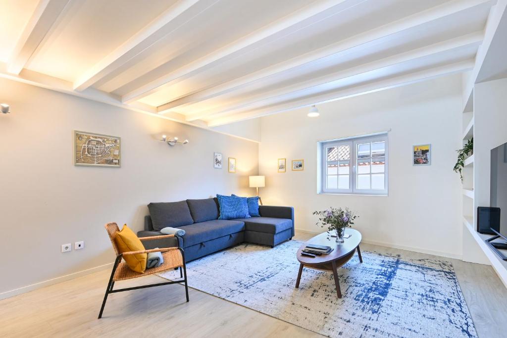 a living room with a blue couch and a table at Ao Pé da Sé next to Braga Cathedral By Sé Apartamentos in Braga