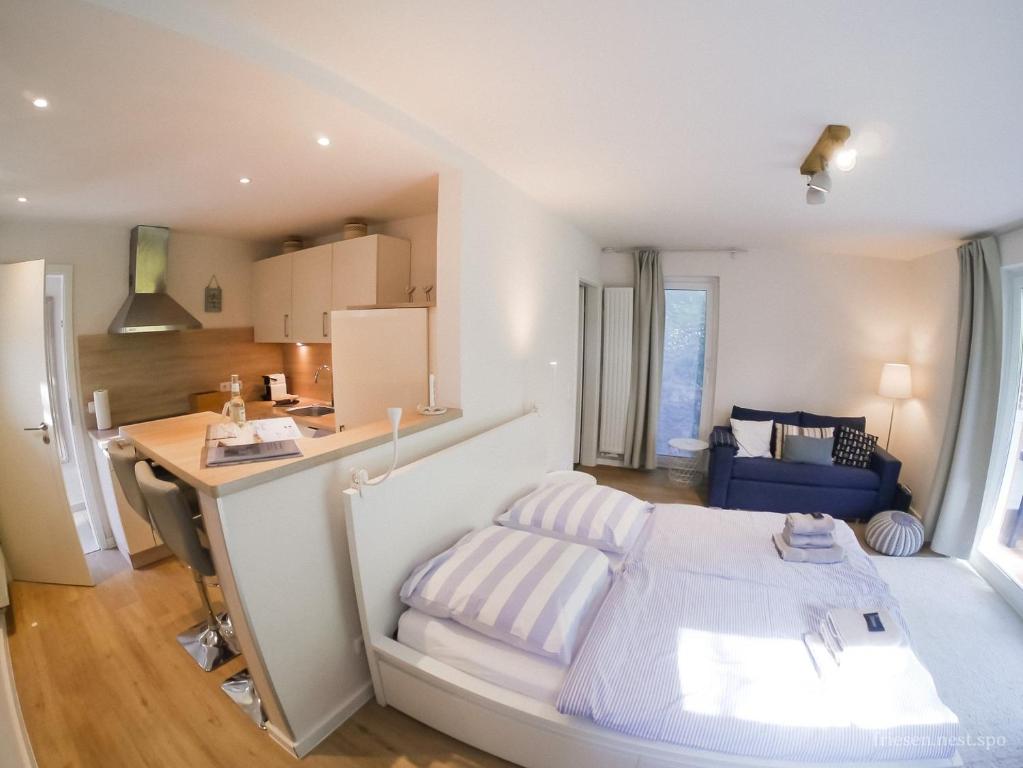 a bedroom with a bed and a desk and a kitchen at friesen-nest-spo in Böhl