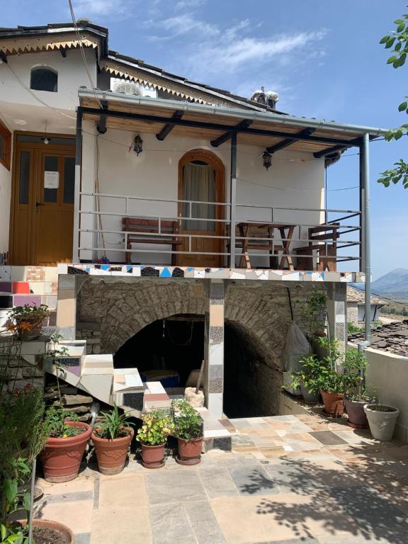 a house with a balcony with plants on a patio at Villa Zeko in Gjirokastër
