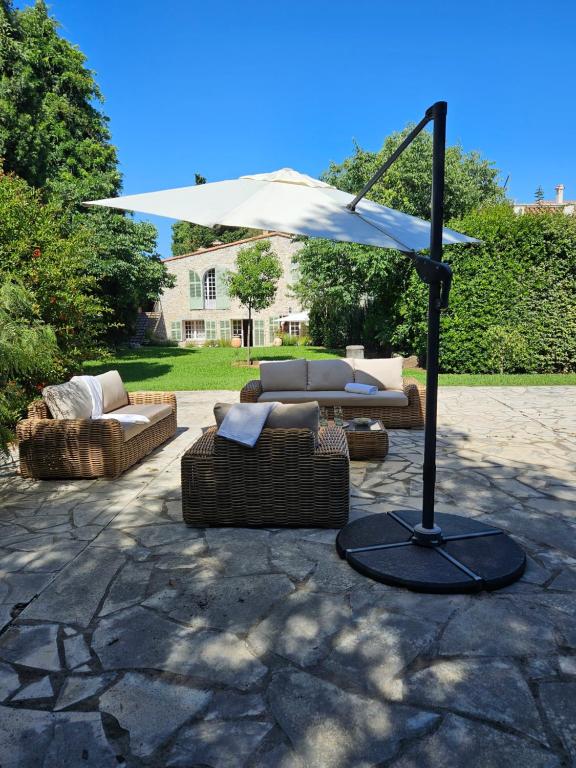 - deux canapés et un parasol sur la terrasse dans l'établissement Mas de charme avec piscine, à Antibes