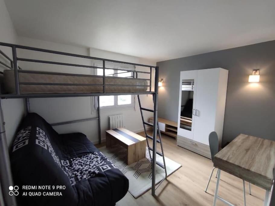 Cette petite chambre comprend des lits superposés et un bureau. dans l'établissement Grand appartement à 3mn de la plage, à Saint-Nazaire