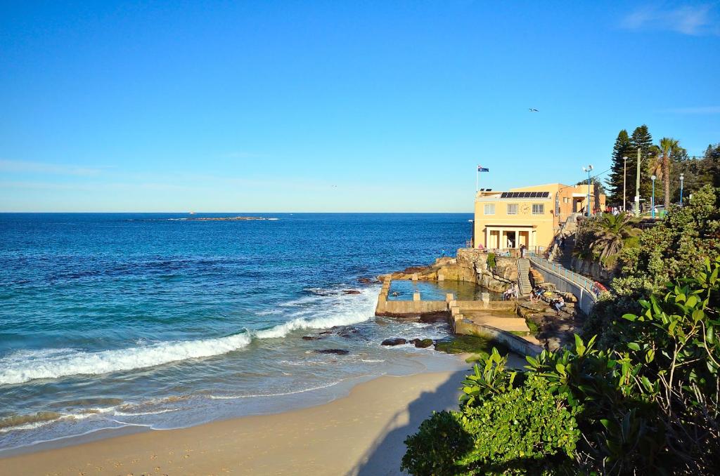 - une plage avec un bâtiment et l'océan dans l'établissement Dive Hotel, à Sydney