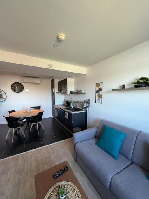 un salon avec un canapé bleu et une table dans l'établissement JOIA Bassin d'Arcachon - LE ROOF 269, à La Teste-de-Buch