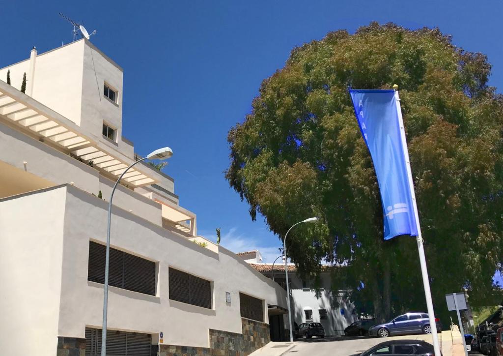 un drapeau bleu sur un pôle devant un bâtiment dans l'établissement Apartamentos Doña Carmen, à Malaga