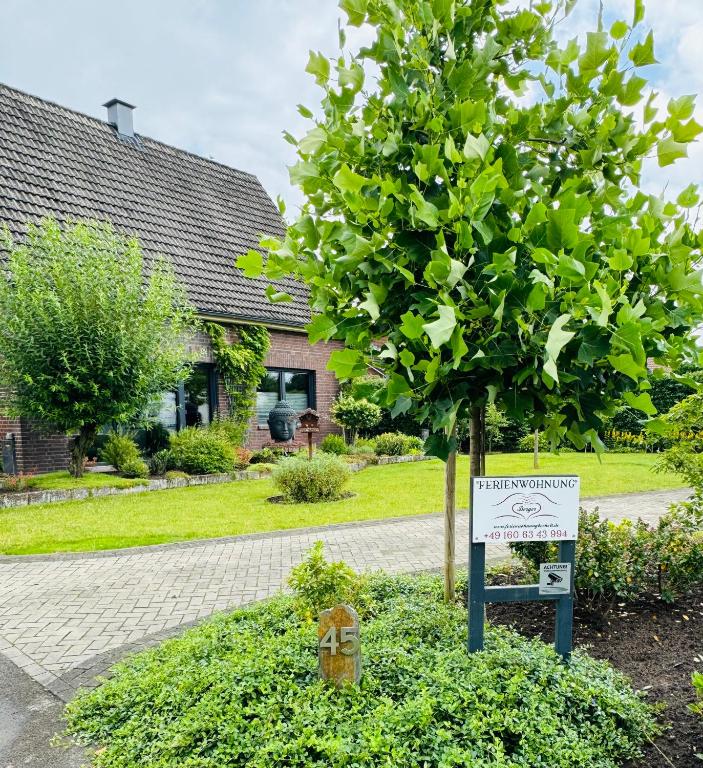 a tree with a sign in front of a house at Ferienwohnung Berger Bocholt in Bocholt