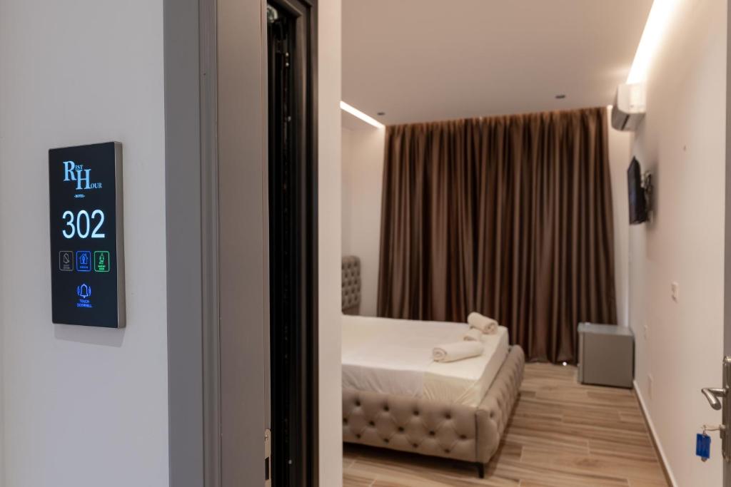 a bedroom with a bed and a clock on the wall at Rest Hour Hotel in Ksamil